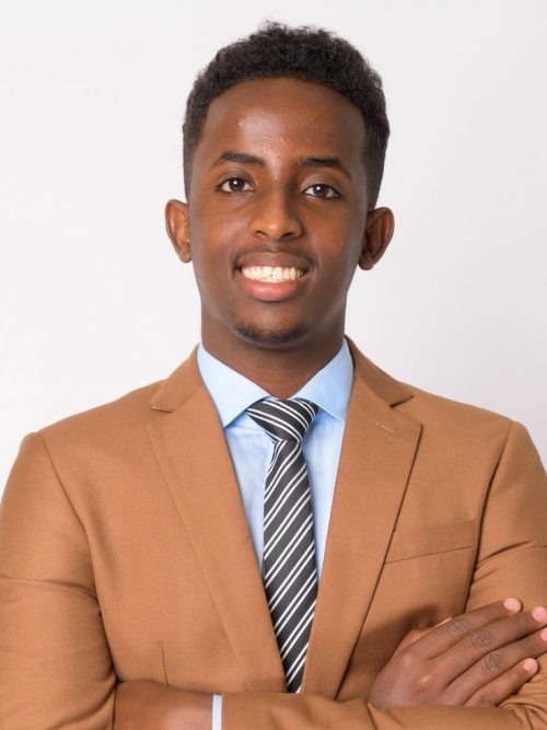 portrait-of-young-happy-african-businessman-smiling-with-arms-crossed-e1624349191613.jpg